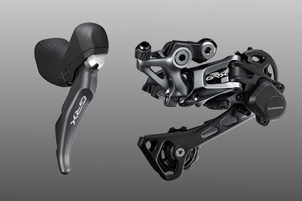 Shimano GRX bike shifter and derailer on gray background