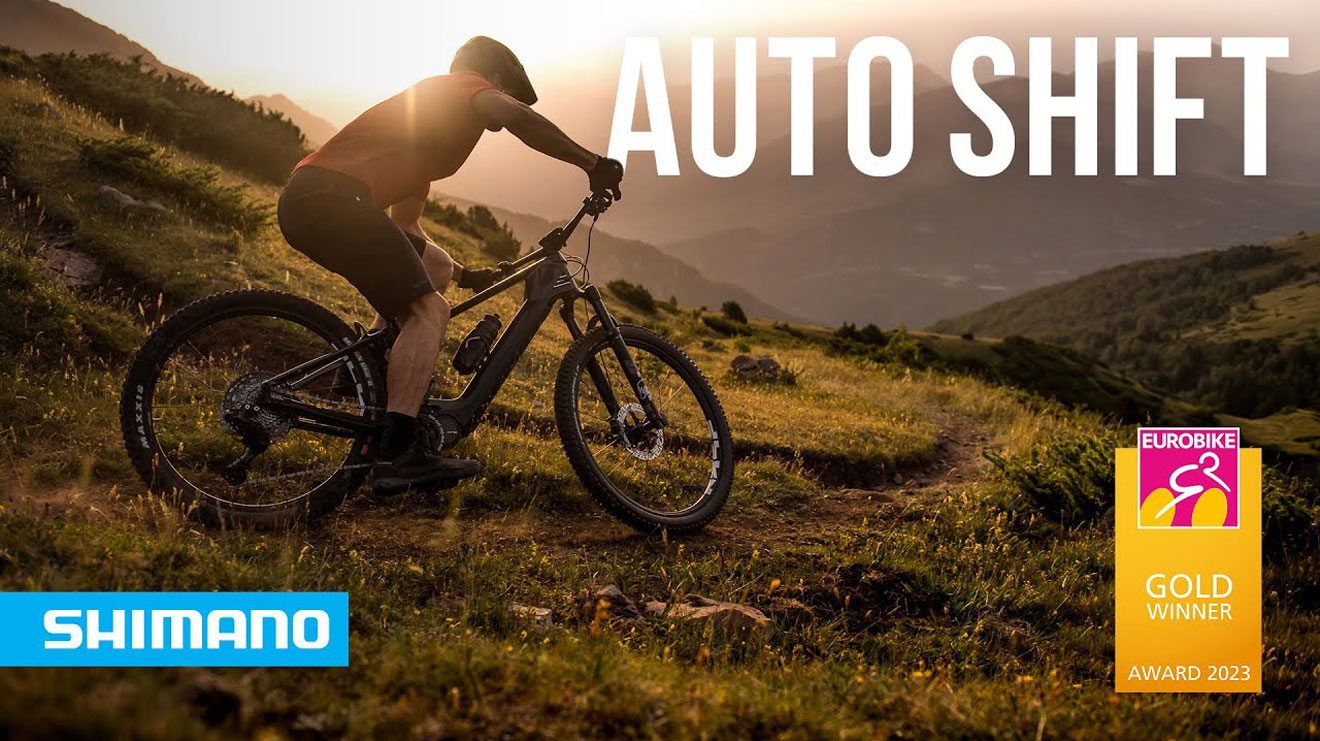 Cyclist riding a mountain bike on a trail with text 'Auto Shift', Shimano logo, and Eurobike Gold Winner Award 2023.
