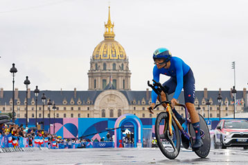 Radsportler fährt bei einem Rennen vor einem historischen Gebäude