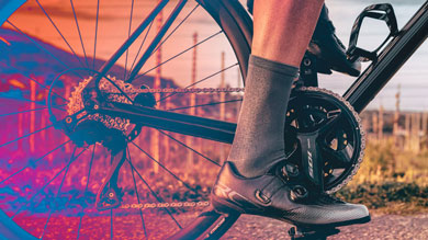Close-up of a cyclist's foot on a bike pedal with a colorful background