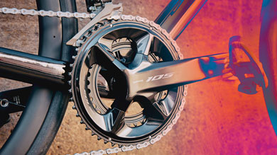 Close-up of a Shimano 105 bike crankset with chain on the gear ring