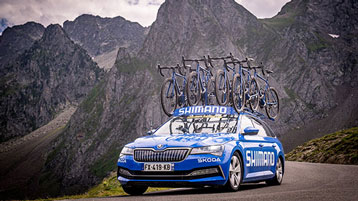 Blue Shimano car carrying bicycles in a mountainous area