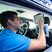 Man using touchscreen tablet mounted in car interior