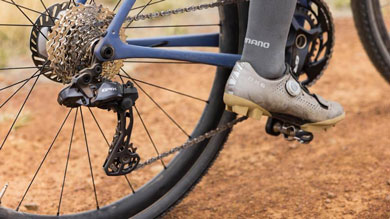 Close-up of a cyclist's foot on a pedal, focusing on the bicycle drivetrain system.