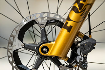 Person removing battery from electric bike mounted on the rear rack
