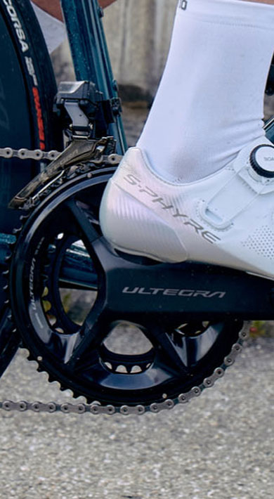 Cyclist wearing white shoes on a road bike with Shimano Ultegra components