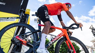 Un coureur en maillot rouge sur un vélo Pinarello pendant une course