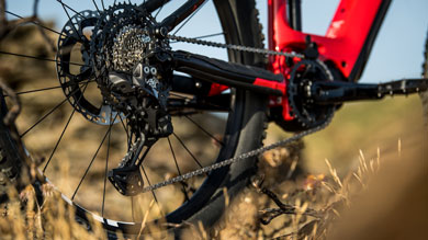 Close-up of the rear derailleur and cassette on a red mountain bike.