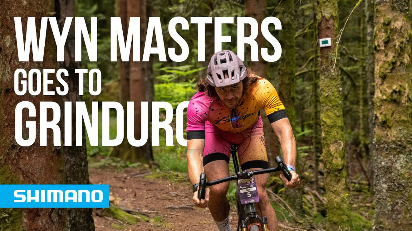 Cyclist riding through the woods with text 'Wyn Masters Goes to Grinduro' and Shimano logo
