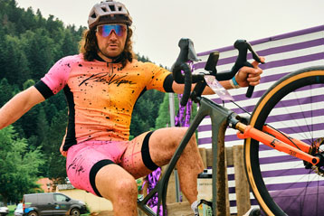 Cyclist in colorful jersey and helmet performs a bike trick outdoors